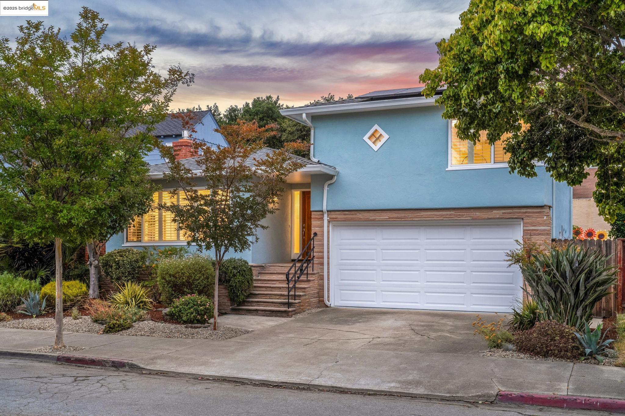 a front view of a house with a tree