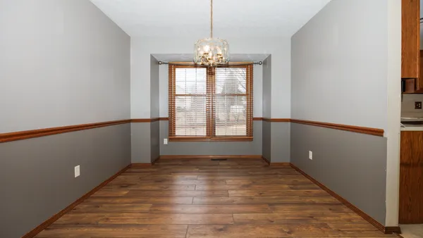 a view of a room with wooden floor and a sink