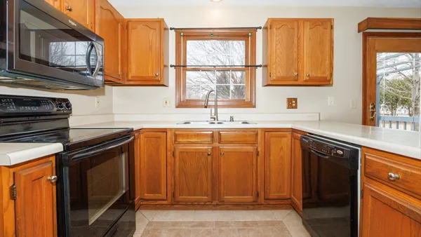 a kitchen with granite countertop a sink stainless steel appliances cabinets and a window