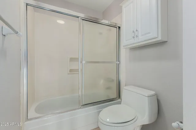 a white toilet next to a bathroom