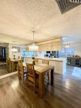 a dining hall with stainless steel appliances kitchen island granite countertop a stove and a sink