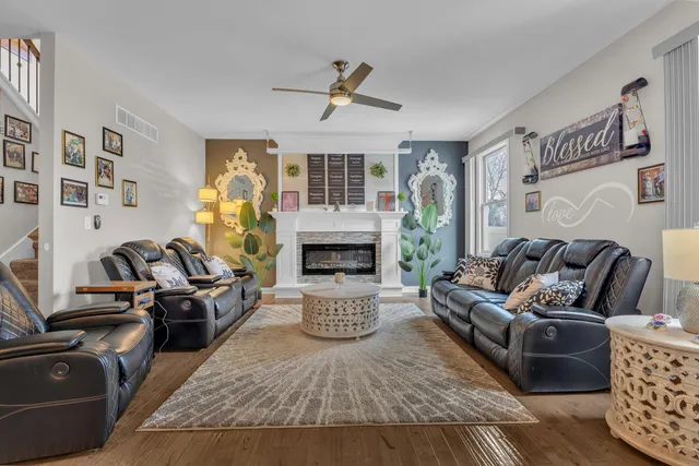 a kitchen with stainless steel appliances kitchen island granite countertop a refrigerator oven stove a sink a dining table and chairs with wooden floor