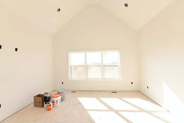 a view of a bedroom with wooden floor and windows