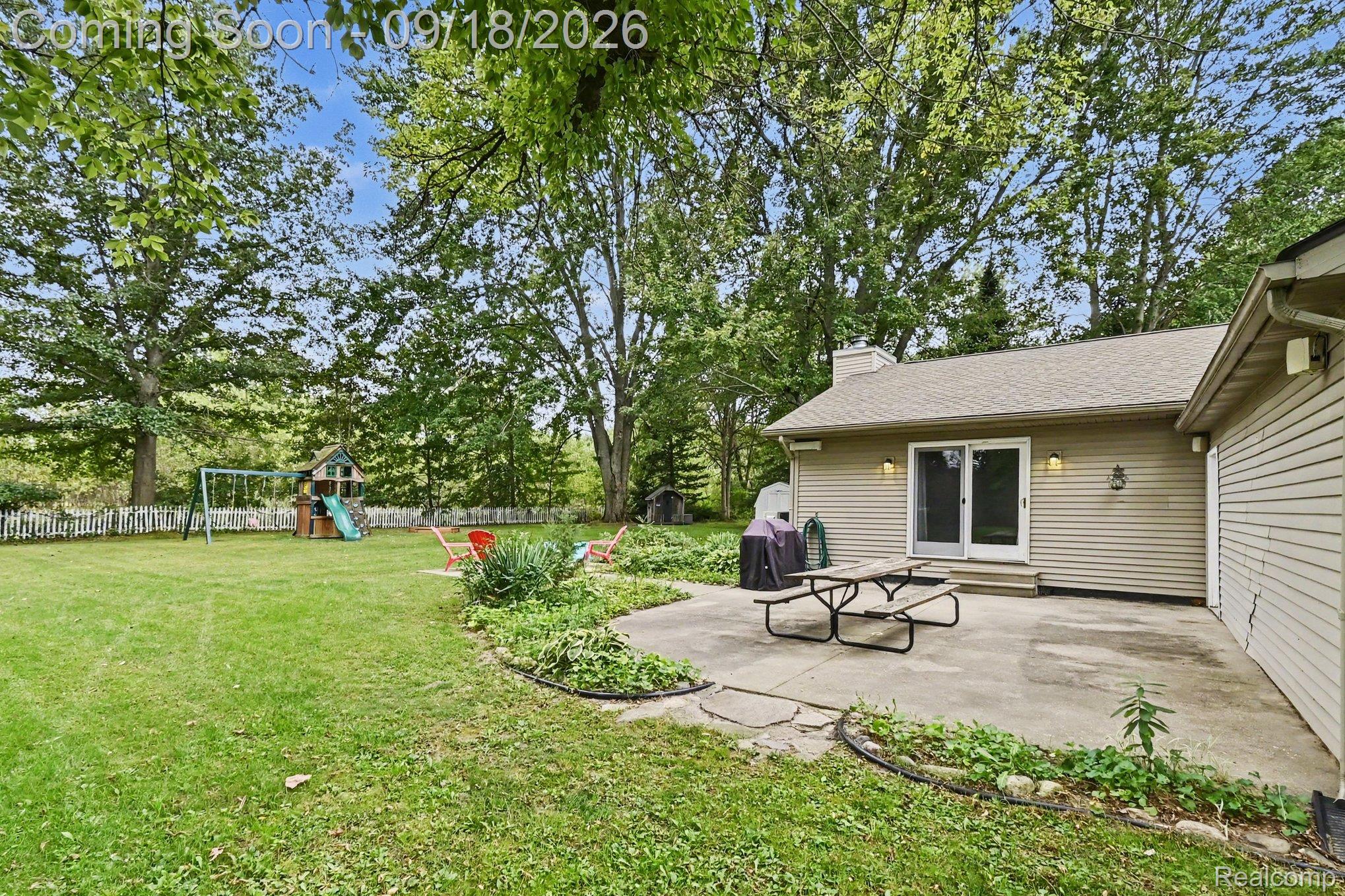 10755 Spencer Road St. Charles, MI 48655 - Photo 28 of 35 Expansive lawn with mature trees and a white picket fence