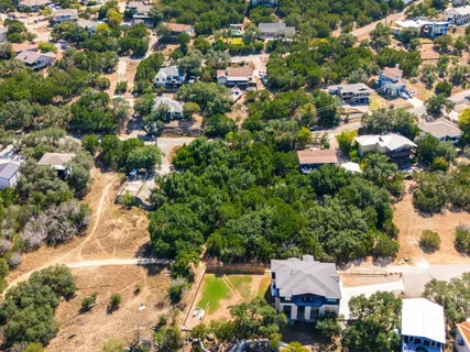 an aerial view of residential houses with outdoor space and trees