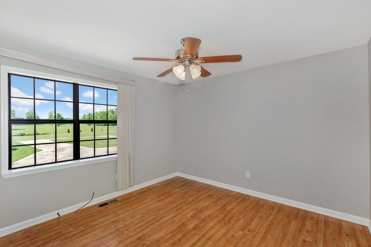 26939 Bethel Road Elkmont, AL 35620 - Photo 17 of 25 a view of empty room with wooden floor and fan