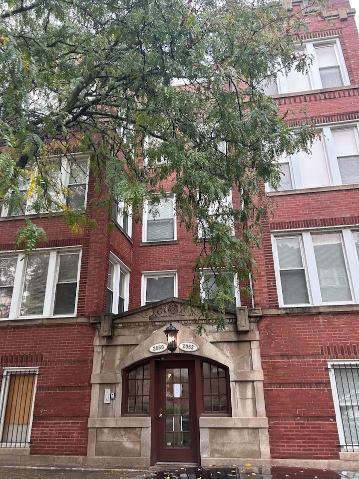 a front view of a building with a garden