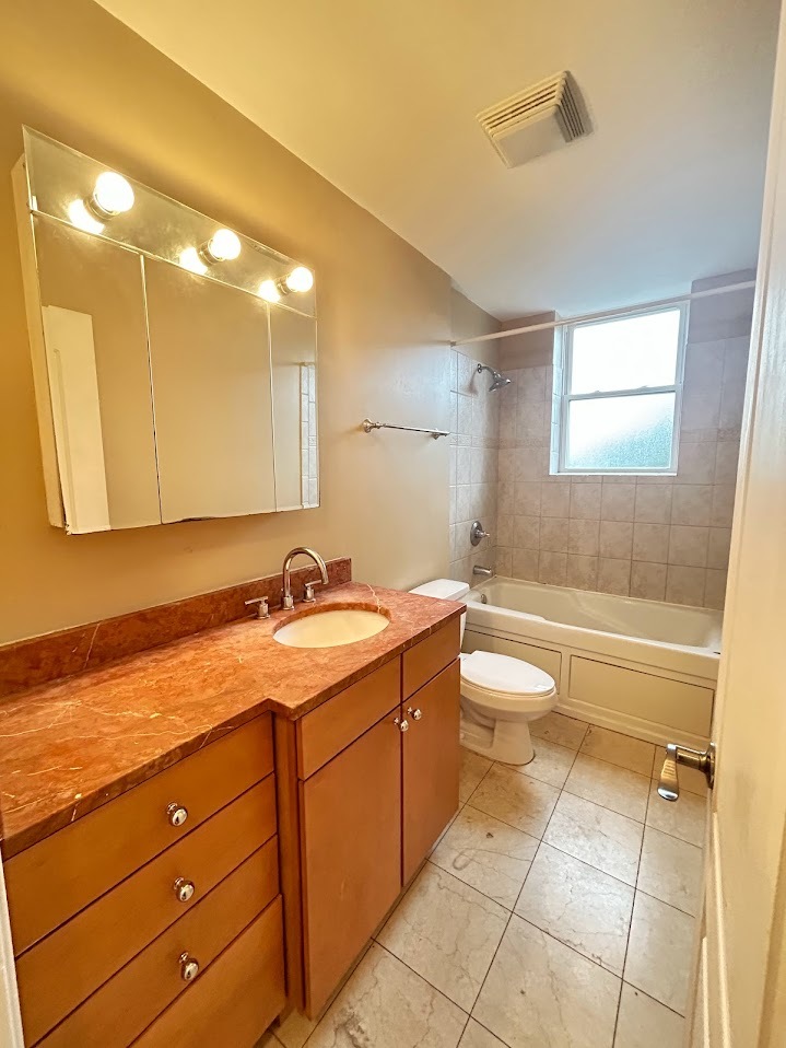 2052 East 68th Street, Unit 3 Chicago, IL 60649 - Photo 2 of 14 a bathroom with a granite countertop sink a toilet and a bathtub