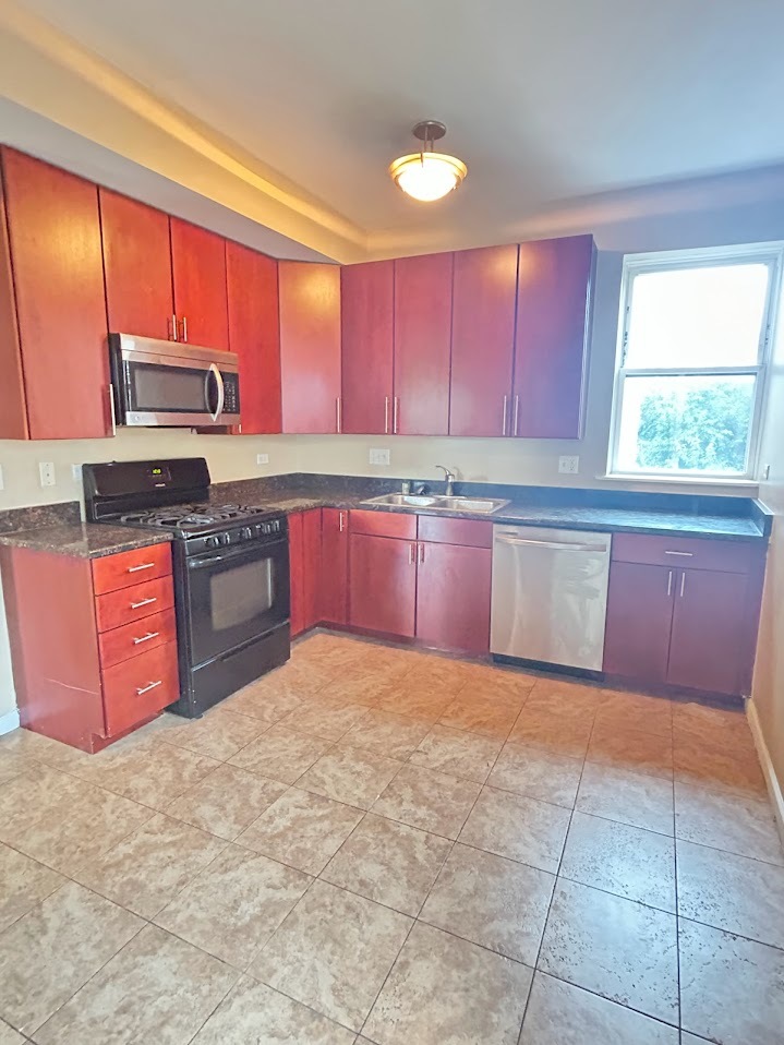 2052 East 68th Street, Unit 3 Chicago, IL 60649 - Photo 6 of 14 a kitchen with stainless steel appliances granite countertop a stove sink and cabinets