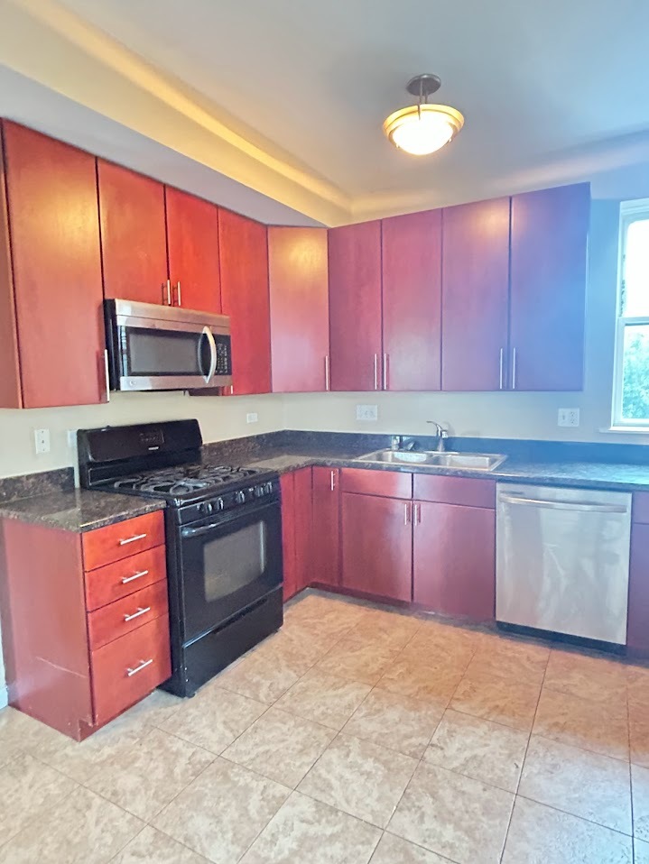 2052 East 68th Street, Unit 3 Chicago, IL 60649 - Photo 8 of 14 a kitchen with stainless steel appliances granite countertop a stove a sink and a microwave