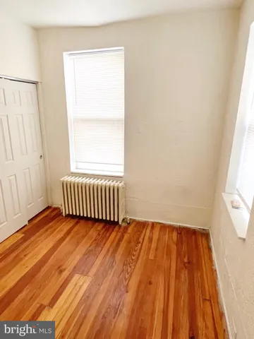 a view of a room with wooden floor and a window