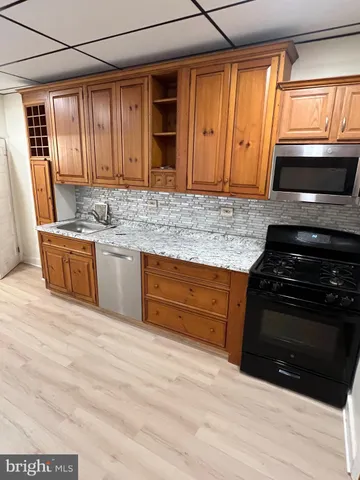 a kitchen with granite countertop stainless steel appliances a stove sink and microwave