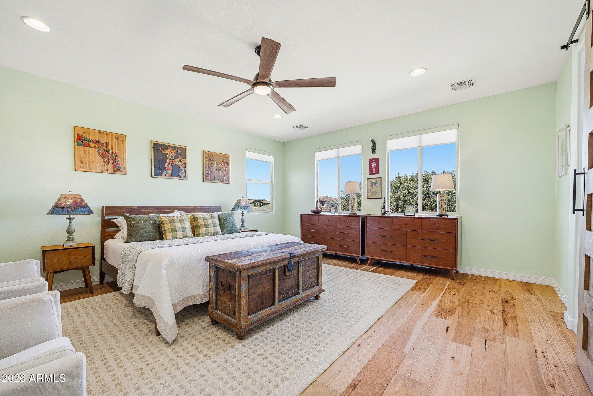 5819 South Wilson Way Gilbert, AZ 85298 - Photo 10 of 76 a bedroom with a large bed and a chandelier