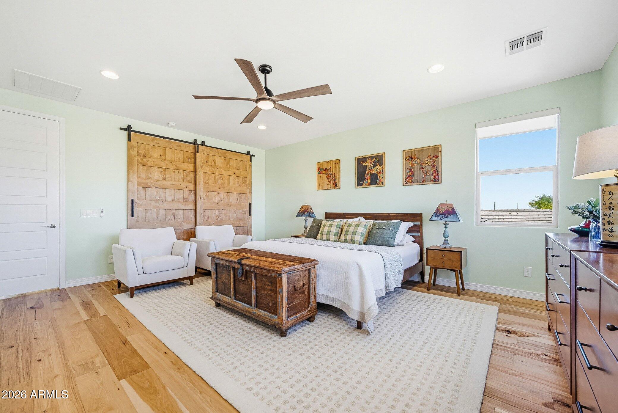 5819 South Wilson Way Gilbert, AZ 85298 - Photo 12 of 76 a spacious bedroom with a bed a couch and a window