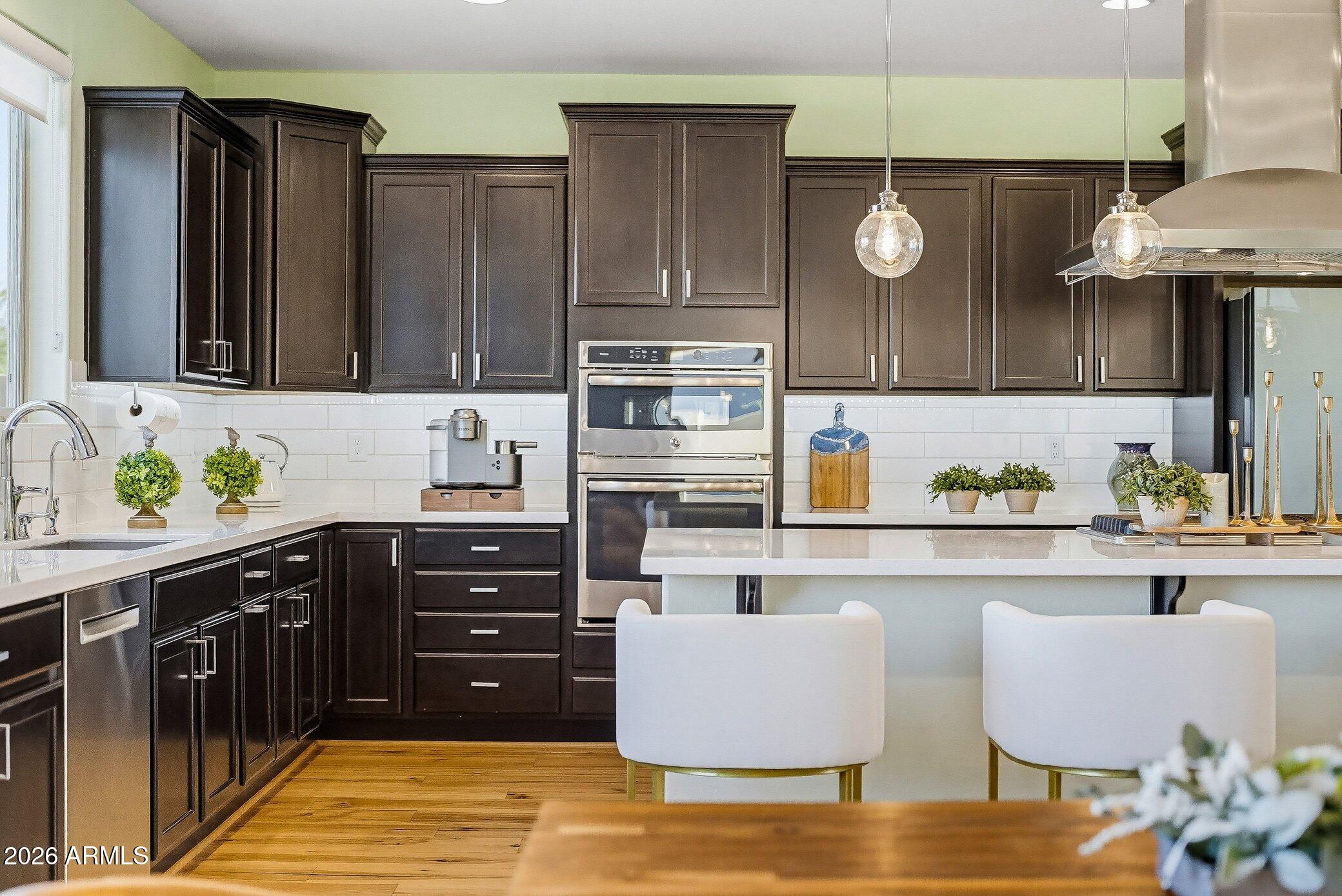 5819 South Wilson Way Gilbert, AZ 85298 - Photo 5 of 76 a kitchen with stainless steel appliances granite countertop a sink and cabinets
