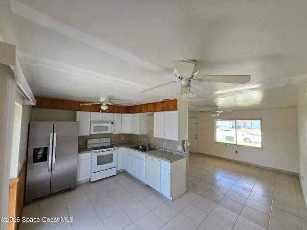 a kitchen with granite countertop a refrigerator and a stove top oven