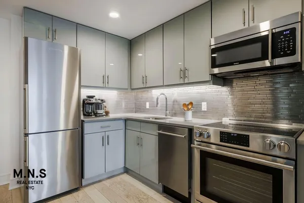 a kitchen with stainless steel appliances granite countertop a refrigerator stove and microwave