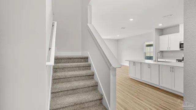 a view of hallway with window and wooden floor