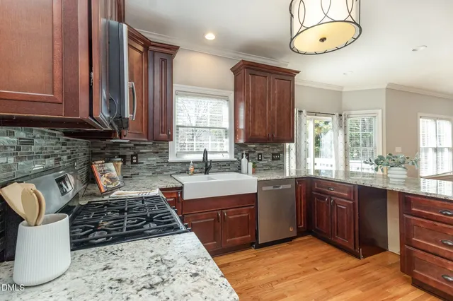 a kitchen with stainless steel appliances granite countertop a stove a sink and a microwave