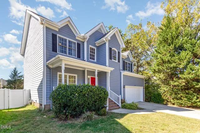 a front view of a house with a yard and trees
