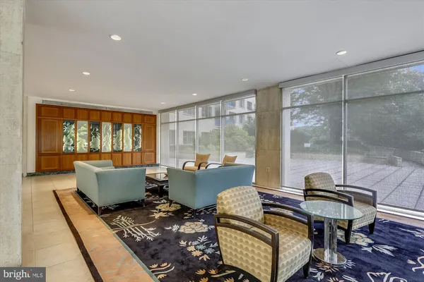 a living room with furniture and a floor to ceiling window