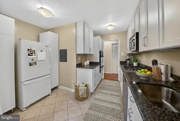a kitchen with stainless steel appliances granite countertop a refrigerator sink and stove