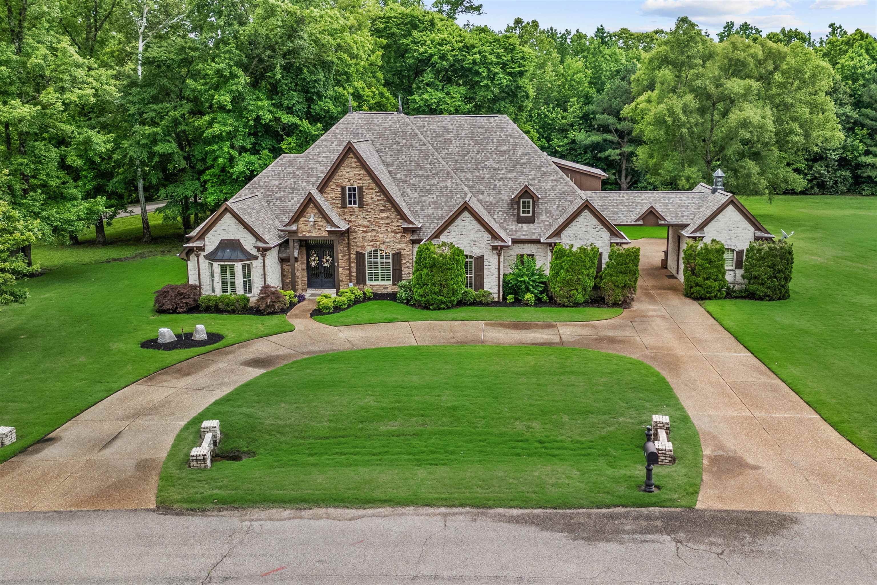 150 Ridgecrest Drive Arlington, TN 38002 - Photo 35 of 40 Traditional-style residence featuring a combination of brick and stone facade, a multi-gabled roof, and a covered breezeway connecting to an additional structure