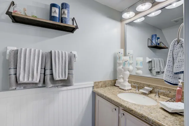 a bathroom with a granite countertop sink and a mirror