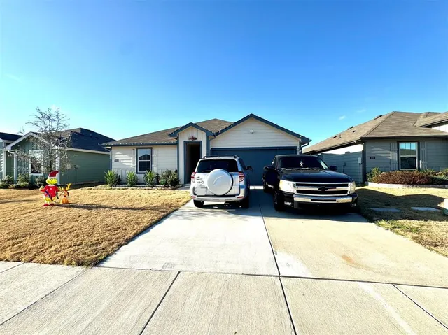 a front view of a house with cars parked on road