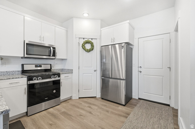 1247 West 1820th Street South Logan, UT 84321 - Photo 6 of 21 Kitchen featuring stainless steel appliances, white cabinetry, granite countertops and a pantry!