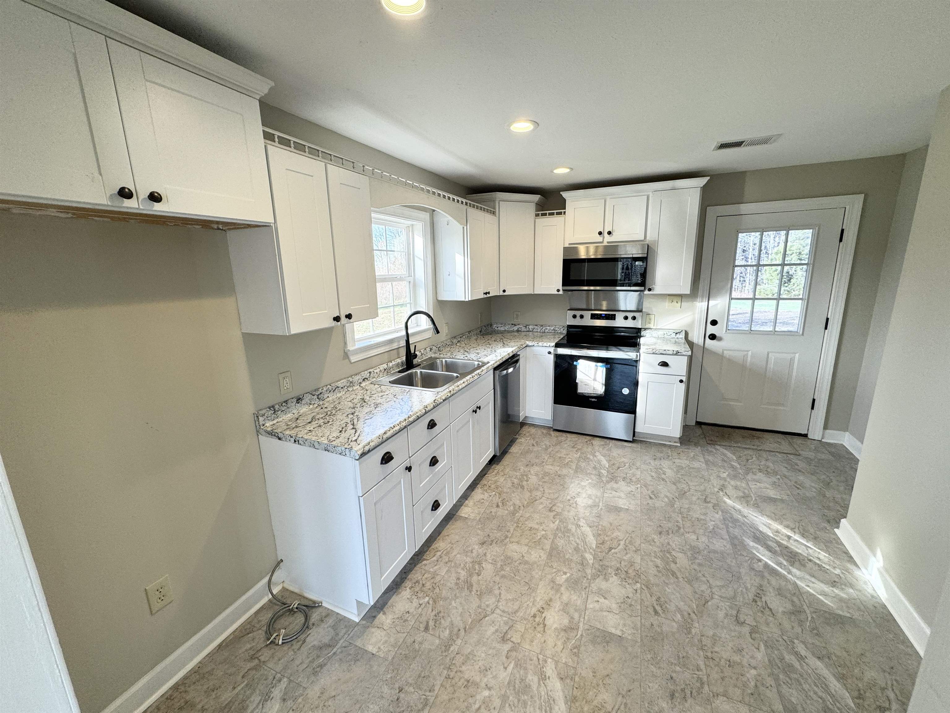 2680 Central Curve Road Ripley, TN 38063 - Photo 8 of 18 a kitchen with granite countertop white cabinets and stainless steel appliances