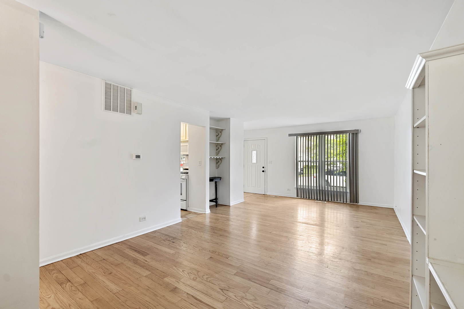 1021 Perry Drive Algonquin, IL 60102 - Photo 2 of 18 a view of an empty room with window and wooden floor