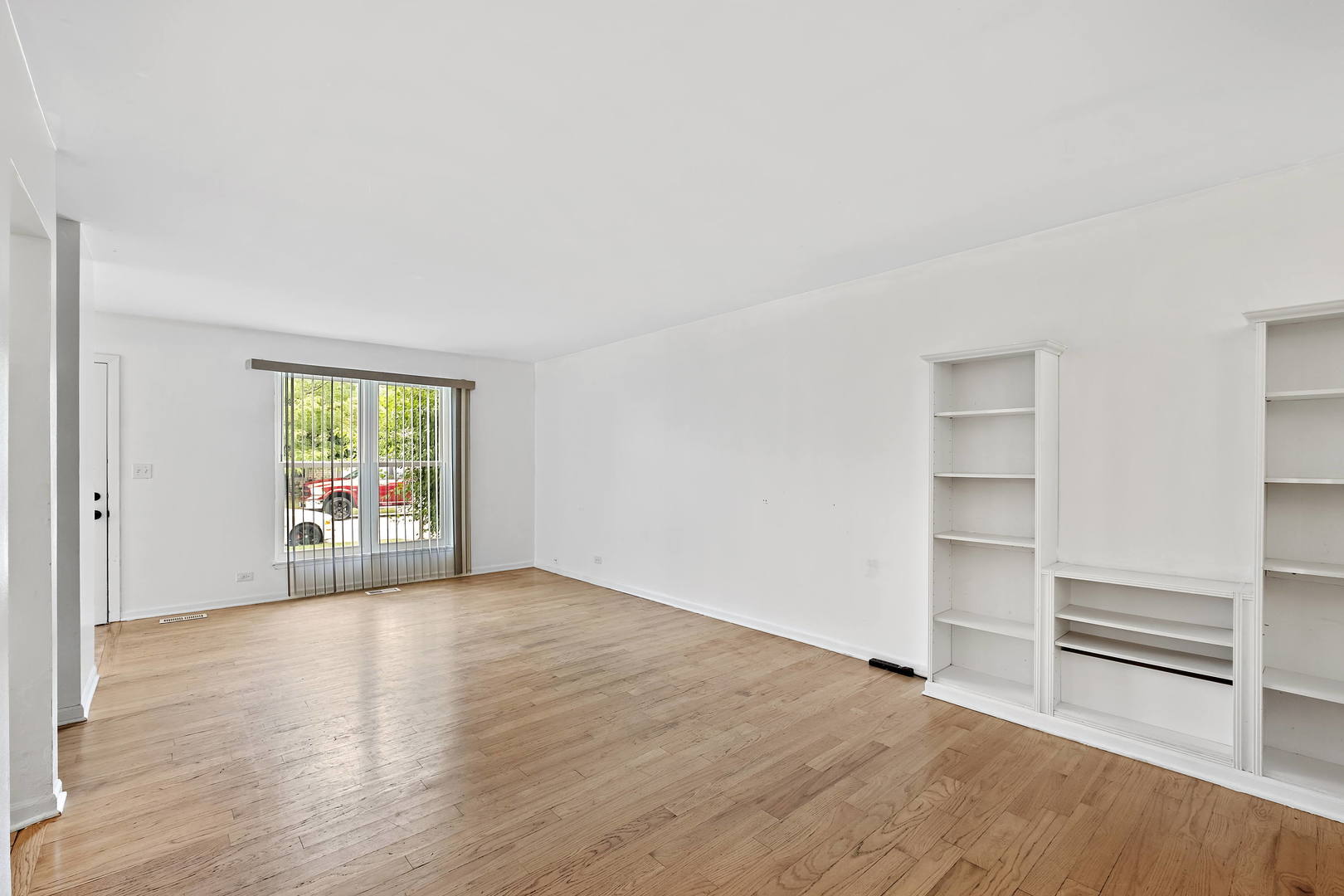 1021 Perry Drive Algonquin, IL 60102 - Photo 3 of 18 a view of an empty room with a window and wooden floor