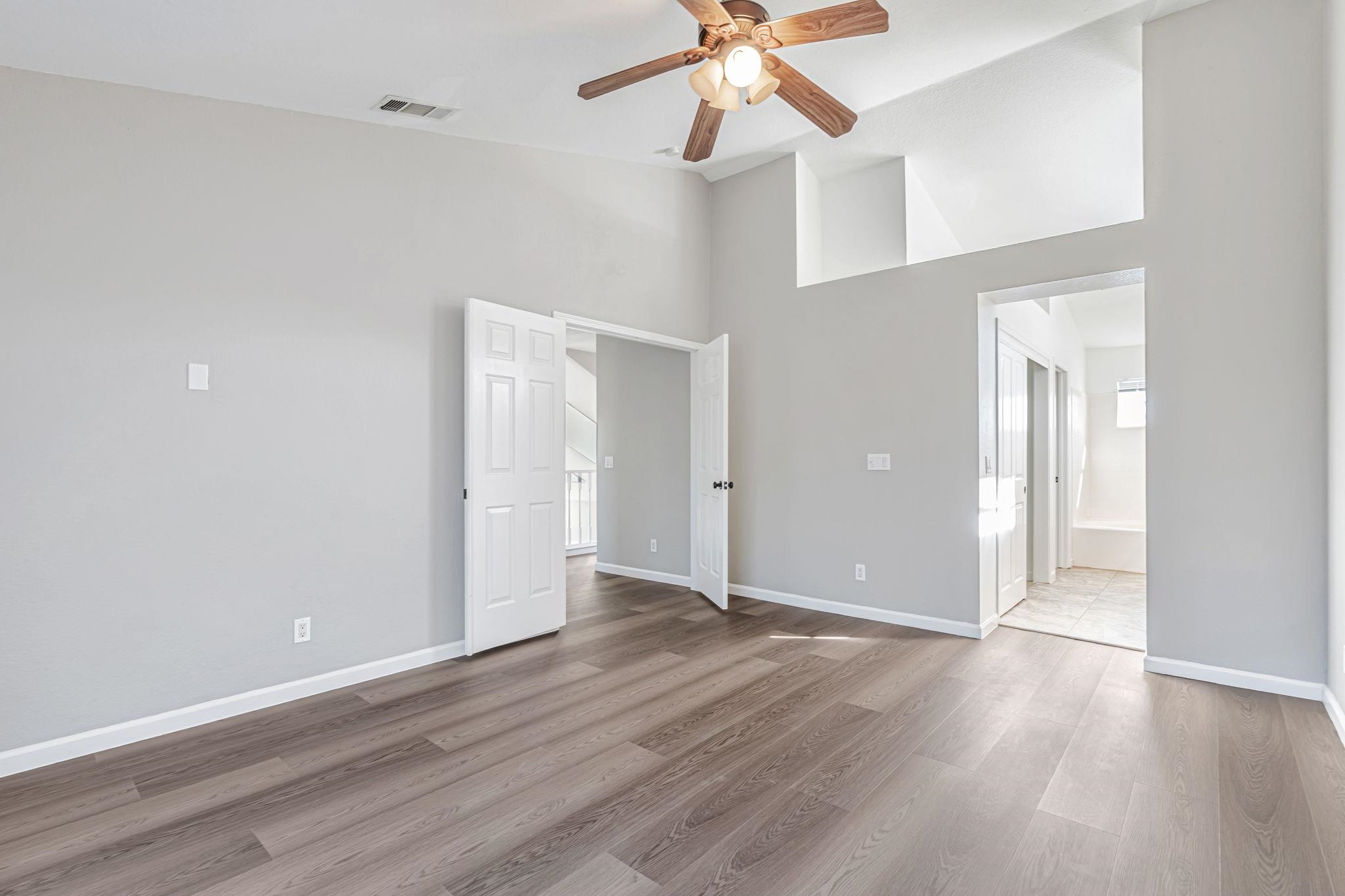 5052 Perry Way Antioch, CA 94531 - Photo 18 of 51 Unfurnished bedroom featuring light wood-type flooring, a ceiling fan, high vaulted ceiling, and connected bathroom