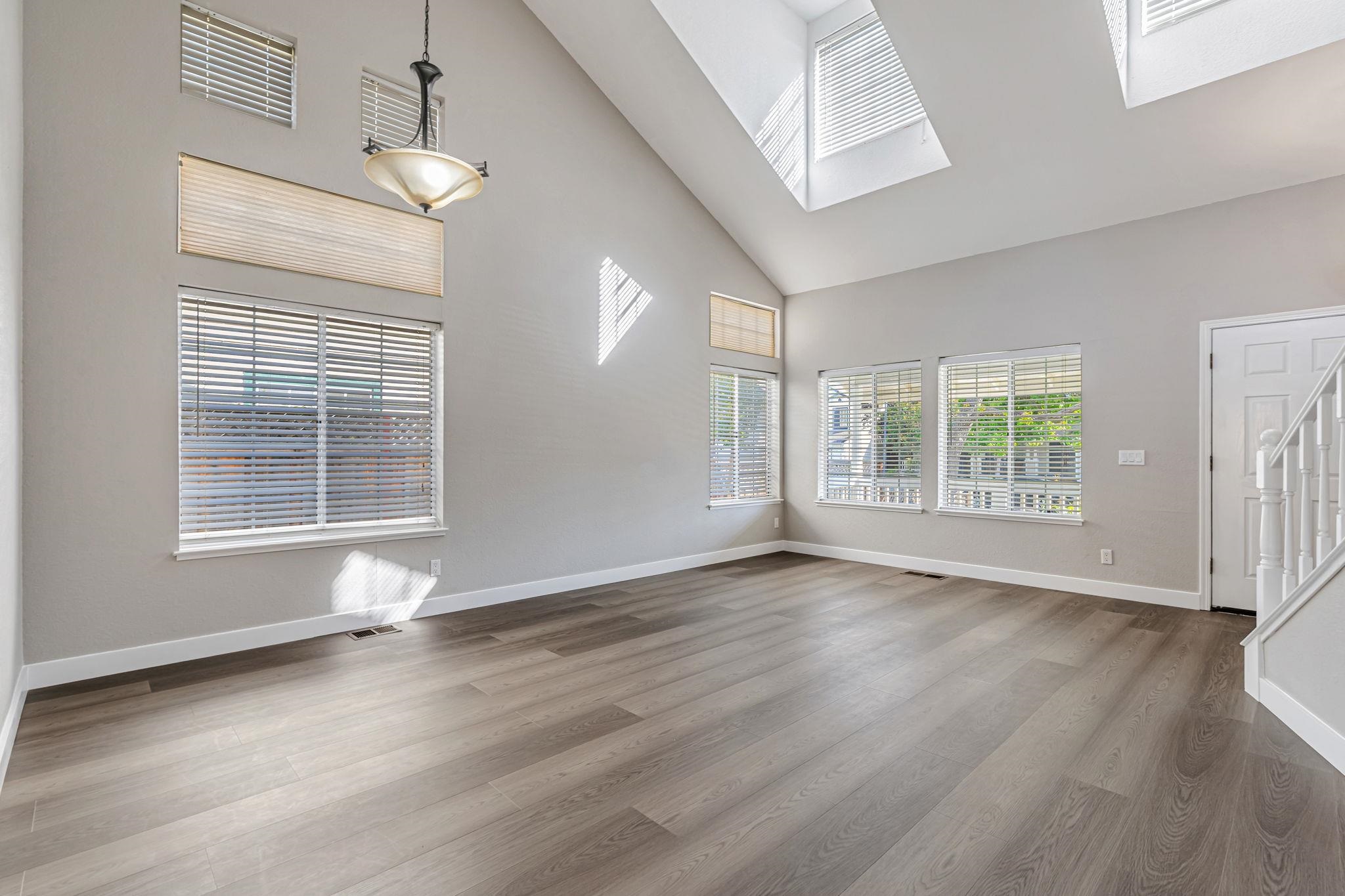 5052 Perry Way Antioch, CA 94531 - Photo 25 of 51 Empty room with light wood finished floors, stairs, high vaulted ceiling, and a skylight