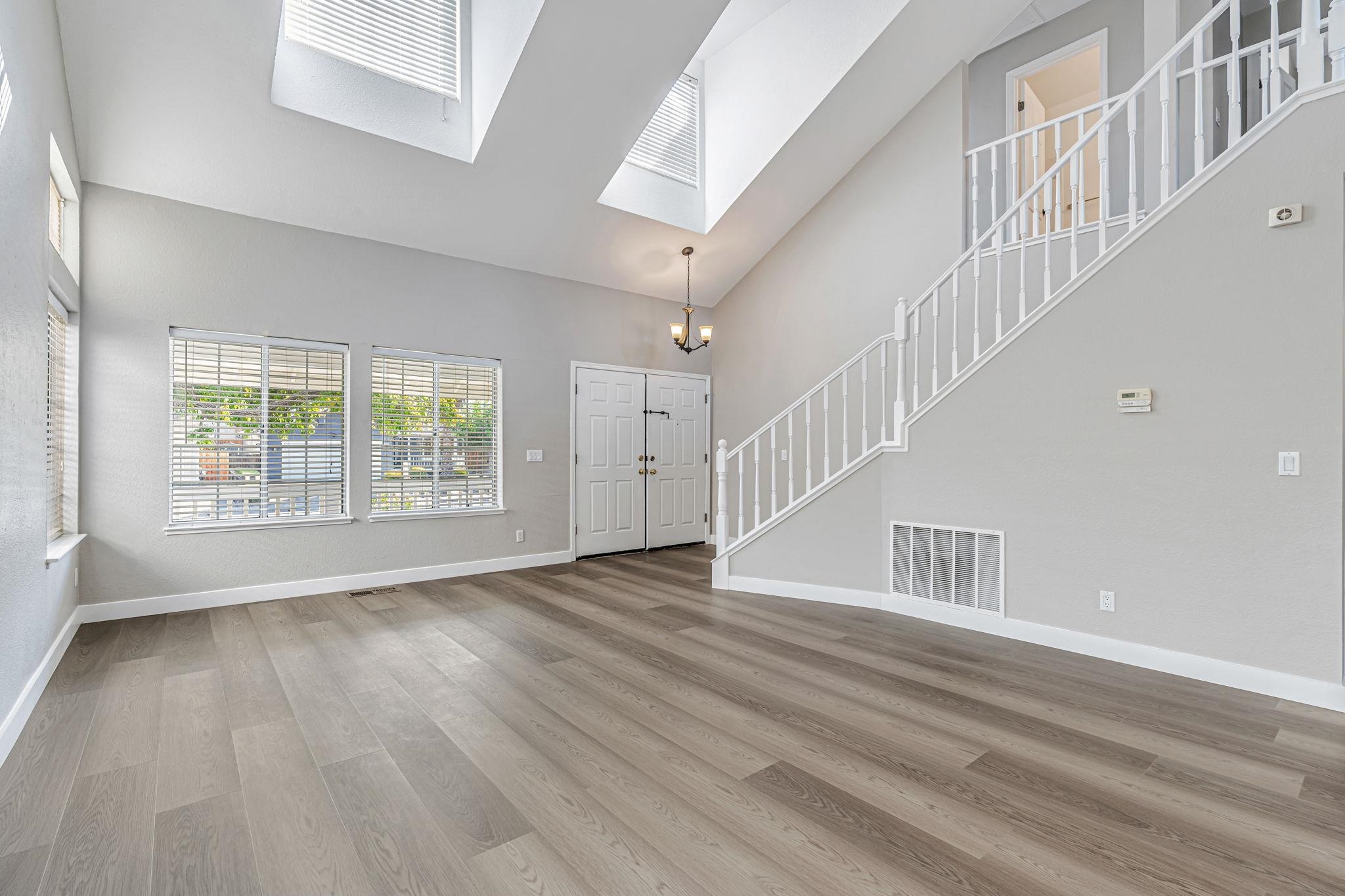5052 Perry Way Antioch, CA 94531 - Photo 6 of 51 Foyer featuring stairway, light wood-style floors, high vaulted ceiling, a chandelier, and a skylight
