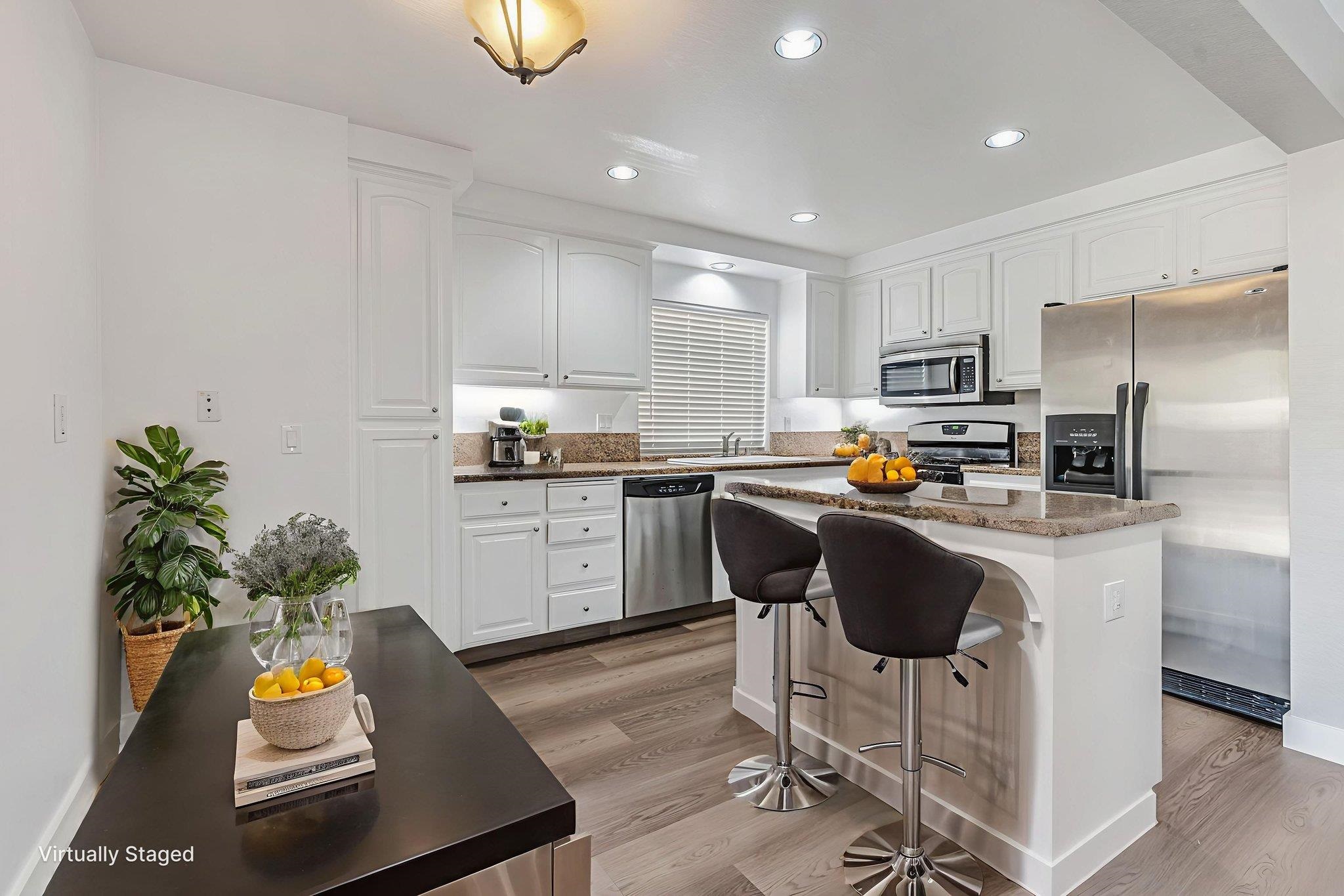 5052 Perry Way Antioch, CA 94531 - Photo 8 of 51 Kitchen with appliances with stainless steel finishes, a breakfast bar area, recessed lighting, white cabinetry, and light wood finished floors