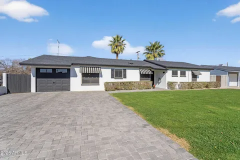 a front view of a house with a garden and yard