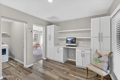 a kitchen with a refrigerator and white cabinets