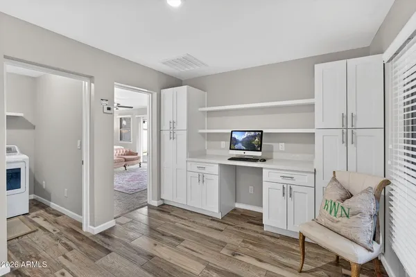 a kitchen with a refrigerator and white cabinets