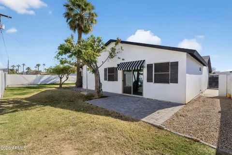 a front view of a house with garden and trees