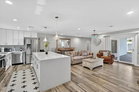 a living room with furniture kitchen view and a window