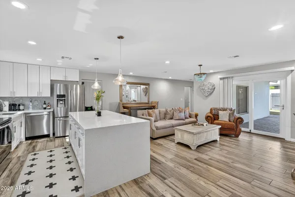 a living room with furniture kitchen view and a window