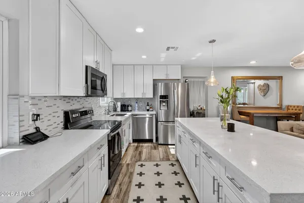 a kitchen with stainless steel appliances granite countertop a stove refrigerator and cabinets