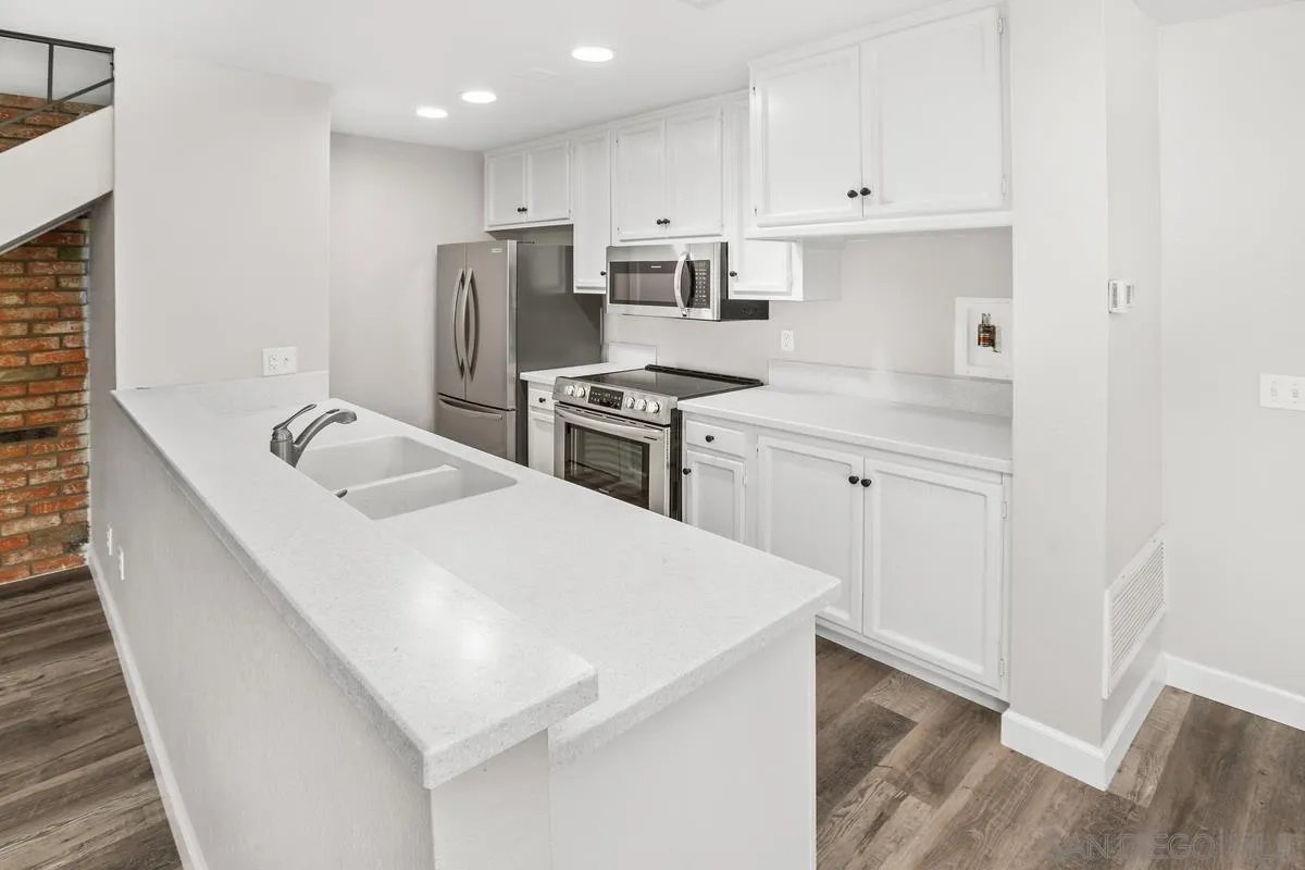 9857 Mission Gorge Road, Unit 2 Santee, CA 92071 - Photo 5 of 11 a kitchen with a sink a stove a refrigerator and white cabinets