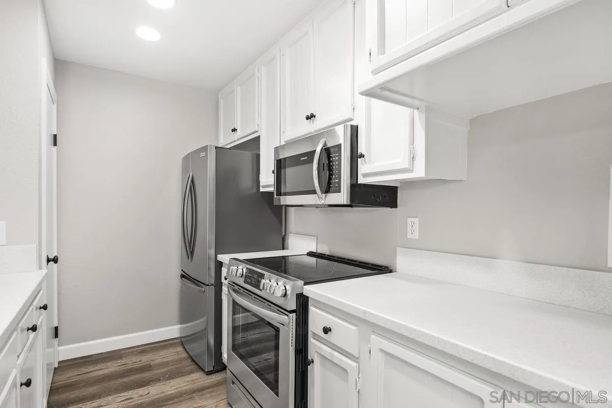 9857 Mission Gorge Road, Unit 2 Santee, CA 92071 - Photo 6 of 11 a kitchen with stainless steel appliances white cabinets and wooden floor