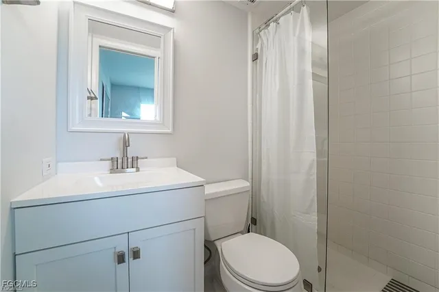 a bathroom with a toilet sink vanity and mirror