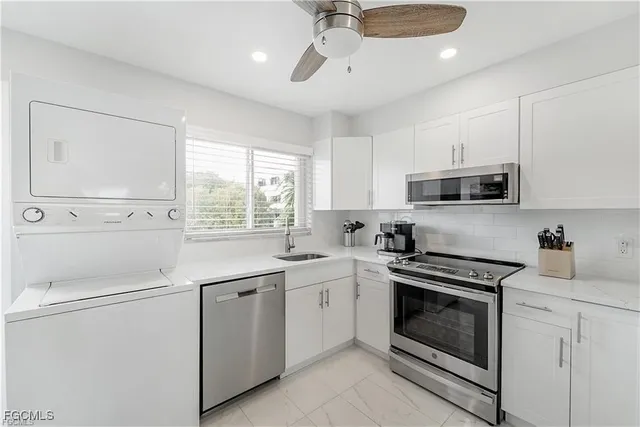a kitchen with white cabinets stainless steel appliances and sink