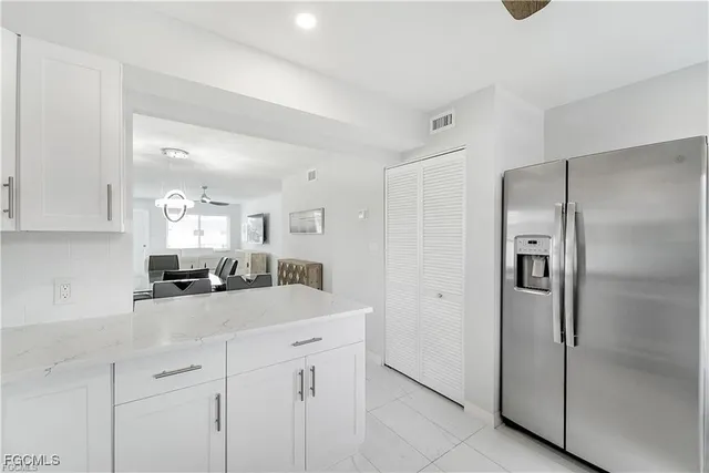 a kitchen with stainless steel appliances granite countertop a refrigerator and a sink