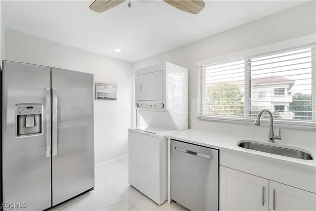 a kitchen with white cabinets and refrigerator